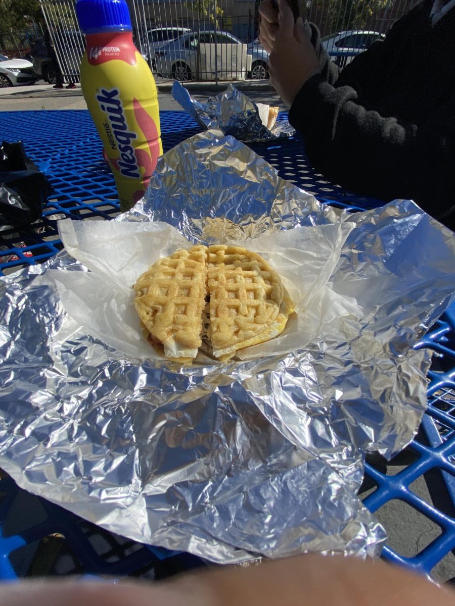 Students eating a bacon egg and cheese on a waffle from AZ Deli and Grill