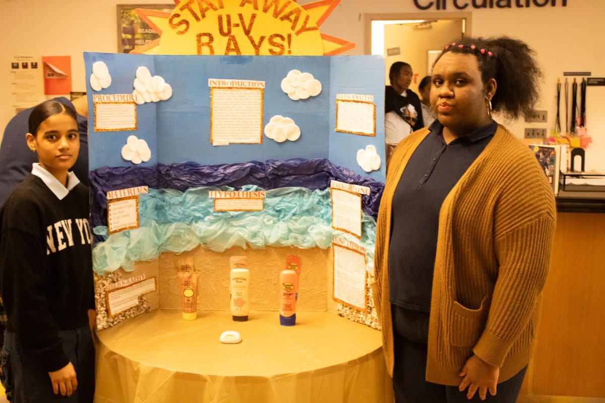 Sophomores Jarelyn de la Cruz and Roselyn Mateo display their investigation into the best sunblock